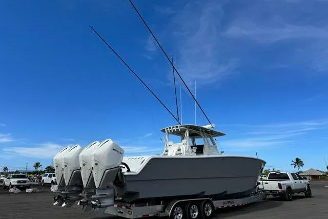 Slide: The Image of 2022 Freeman 37 VH boat on trailer with four engines, under clear blue sky. - 30
