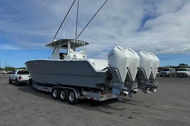 Slide: The Image of 2022 Freeman 37 VH boat on trailer with triple outboard engines, parked outdoors. - 32
