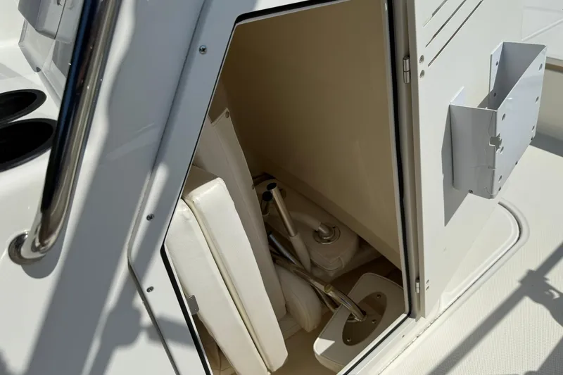 Slide: The Image of 2014 Boston Whaler 210 Montauk interior storage compartment with white cushions and equipment. - 11