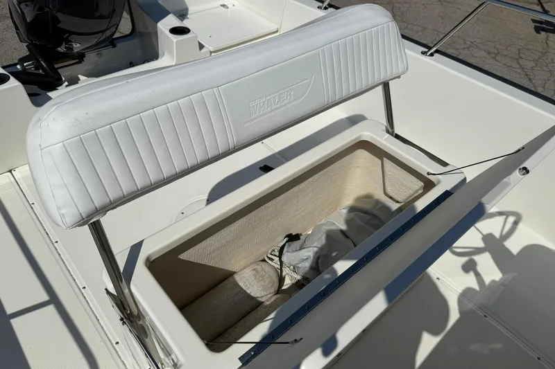Slide: The Image of 2014 Boston Whaler 210 Montauk boat interior with open storage compartment. - 12