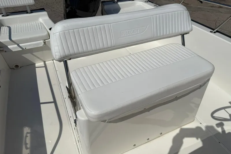 Slide: The Image of 2014 Boston Whaler 210 Montauk boat interior with white cushioned seating. - 13