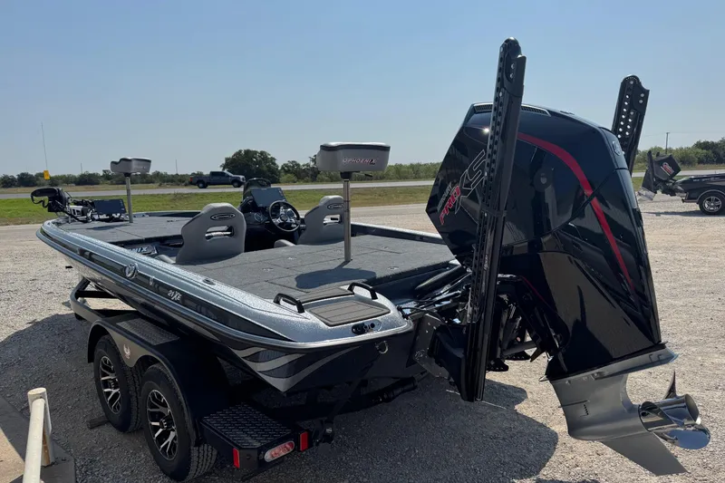 Slide: The Image of 2026 Phoenix 21XE boat with powerful engine, parked on gravel near a road. - 4