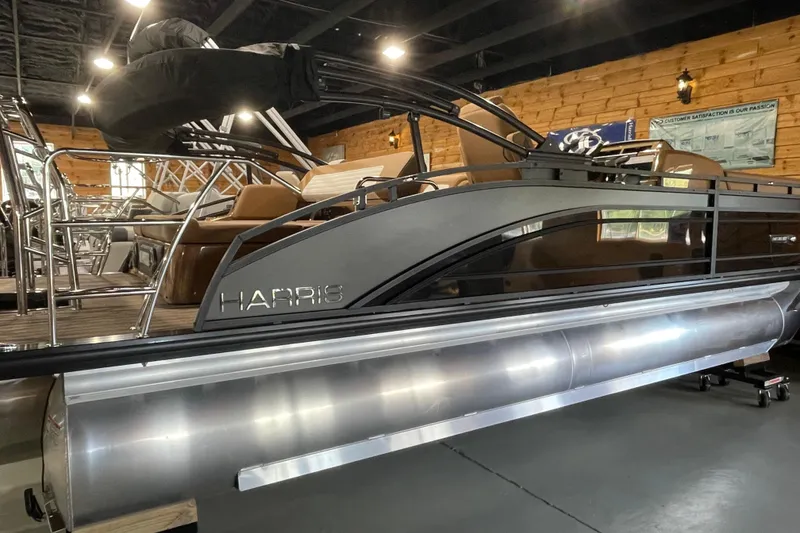 Slide: The Image of 2026 Harris Solstice 230 pontoon boat displayed indoors, showcasing sleek design and modern features. - 2