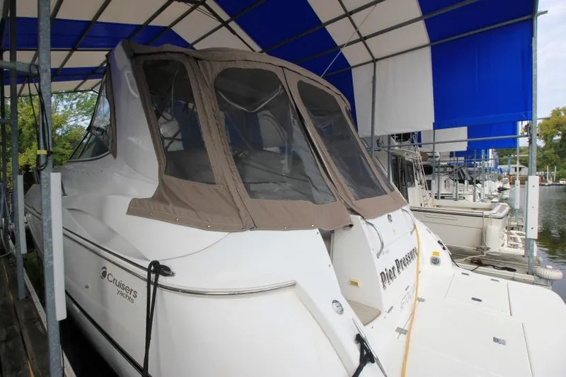 Slide: The Image of 2000 Cruisers Yachts 3672 Express docked under blue canopy. - 3