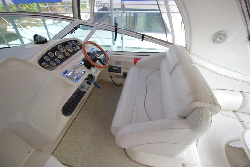 Slide: The Image of 2000 Cruisers Yachts 3672 Express helm with white seating and control panel. - 9