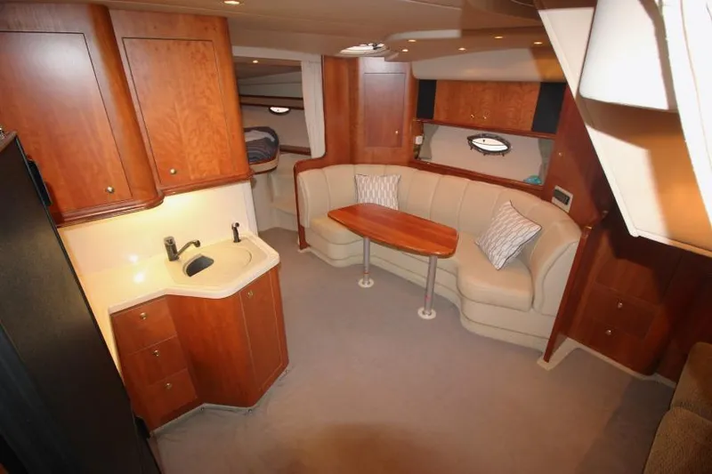 Slide: The Image of Interior of 2000 Cruisers Yachts 3672 Express with wood cabinetry and cozy seating area. - 12