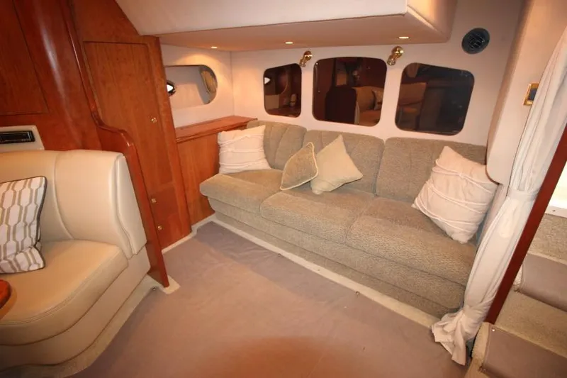 Slide: The Image of Interior of 2000 Cruisers Yachts 3672 Express with beige sofa and wooden cabinetry. - 14