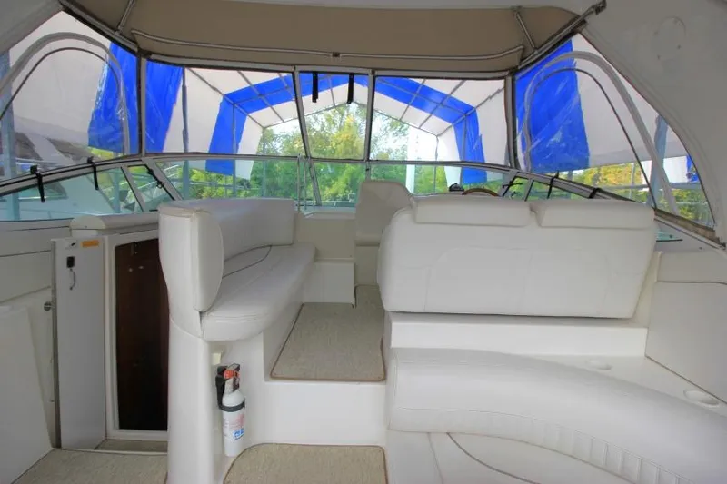 Slide: The Image of Interior of 2000 Cruisers Yachts 3672 Express with white seating and blue canopy. - 7