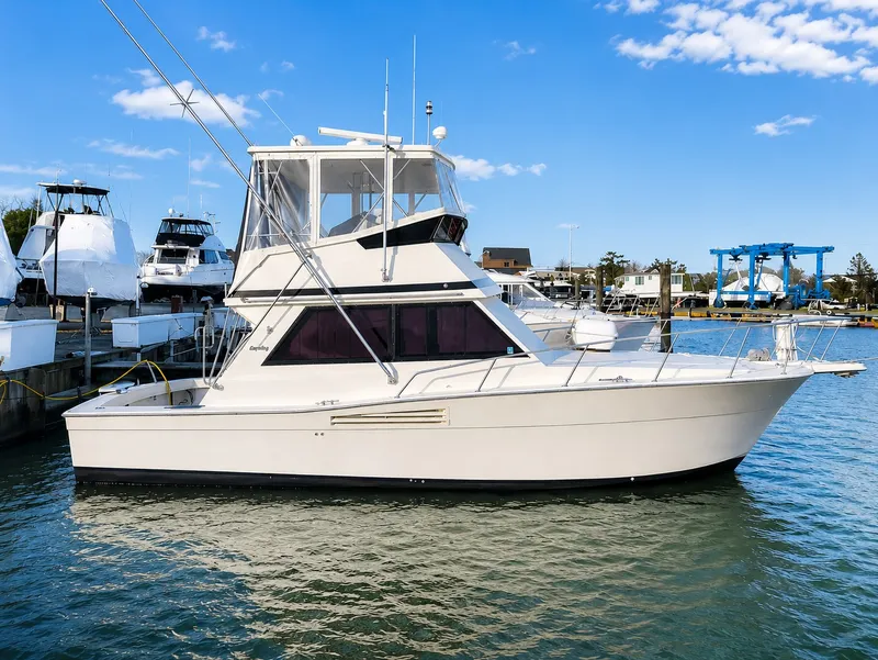 The Image of 1988 Viking 35 Convertible on the water, featuring a flybridge and clear blue sky background. - 0
