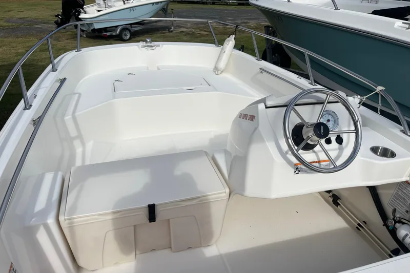 Slide: The Image of 2024 Boston Whaler 160 Super Sport boat interior with steering wheel and seating. - 10