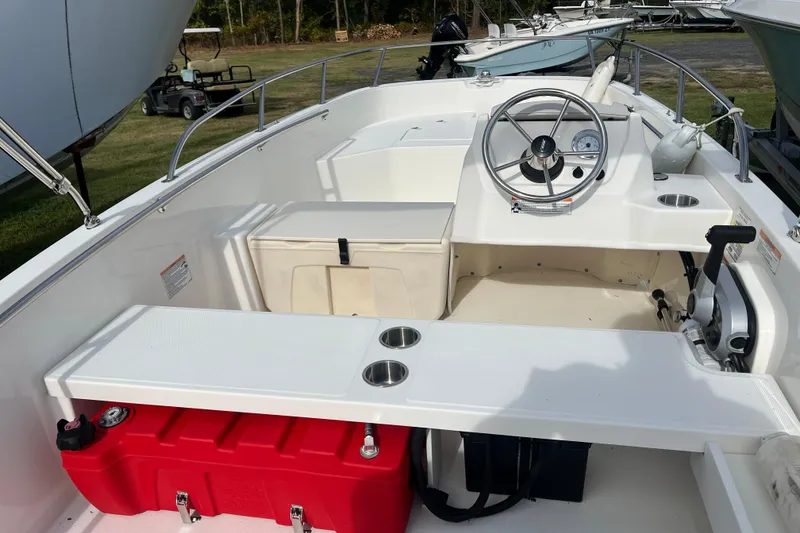 Slide: The Image of 2024 Boston Whaler 160 Super Sport boat interior with steering wheel and seating. - 11