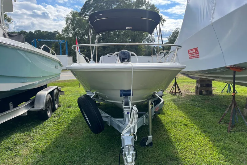 Slide: The Image of 2024 Boston Whaler 160 Super Sport boat on trailer, parked on grass. - 14