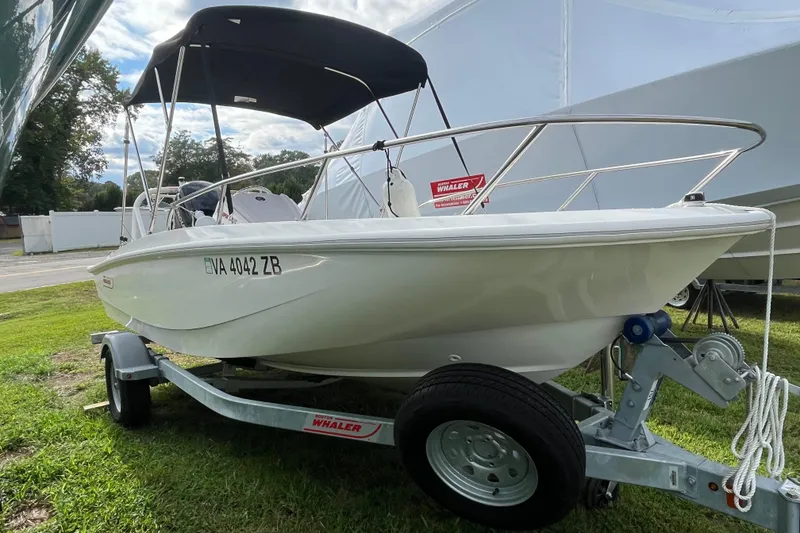 Slide: The Image of 2024 Boston Whaler 160 Super Sport boat on trailer with canopy, parked on grass. - 15
