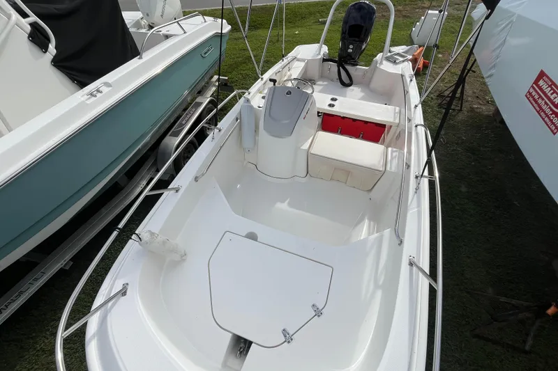 Slide: The Image of 2024 Boston Whaler 160 Super Sport boat, white interior, docked on grass. - 3