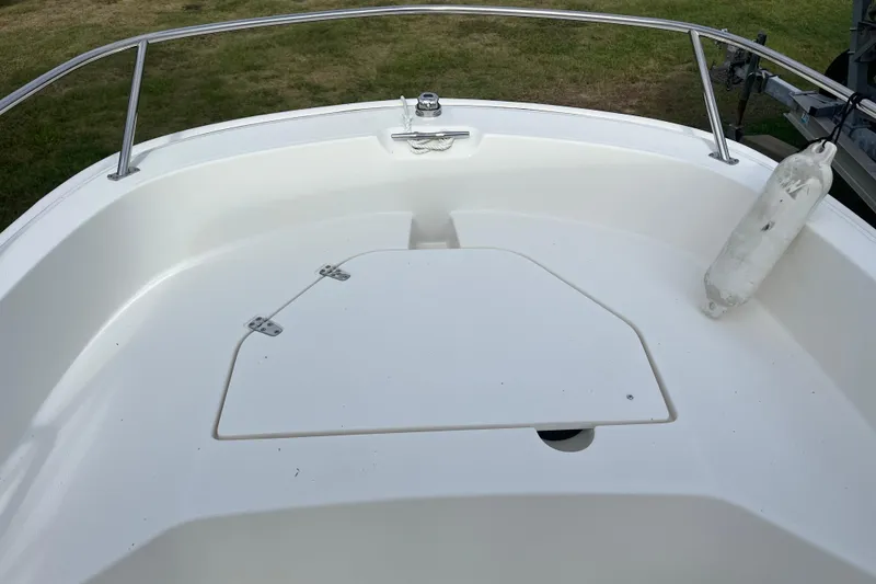 Slide: The Image of 2024 Boston Whaler 160 Super Sport boat deck with storage compartment and railing. - 5
