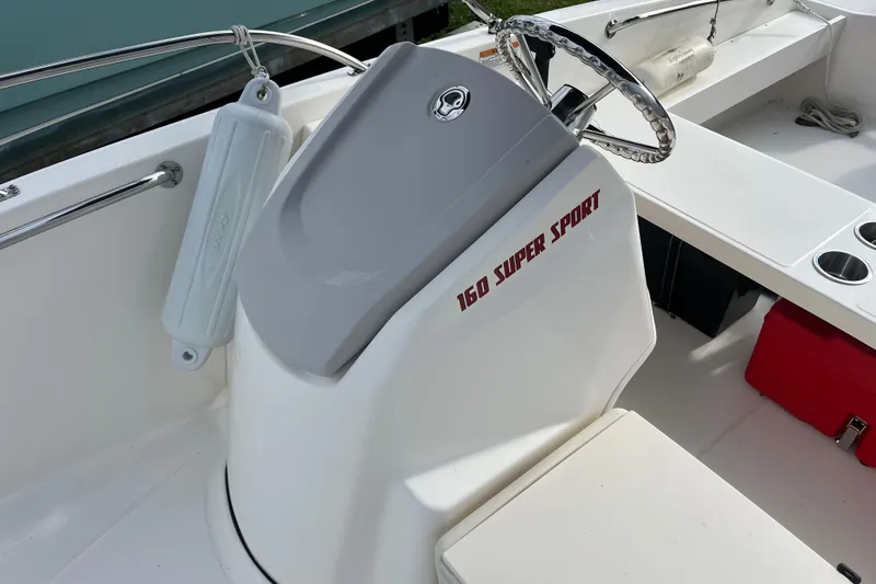 Slide: The Image of 2024 Boston Whaler 160 Super Sport boat interior with steering wheel and seating. - 7