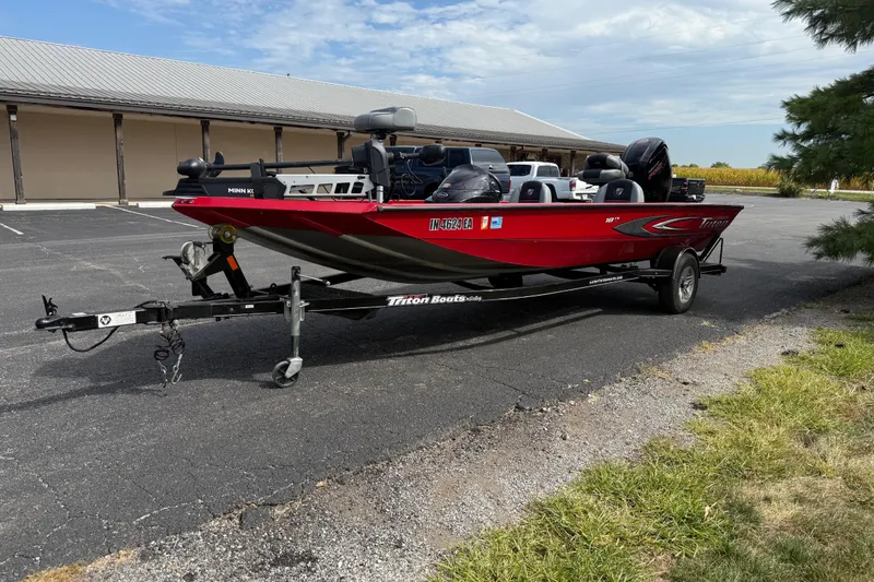Slide: The Image of 2018 Triton 18 TX red fishing boat on trailer in parking lot. - 5