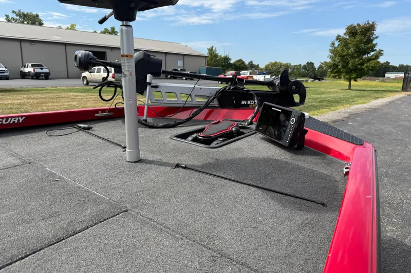 Slide: The Image of 2018 Triton 18 TX boat deck with fishing equipment and electronics, parked outdoors. - 8