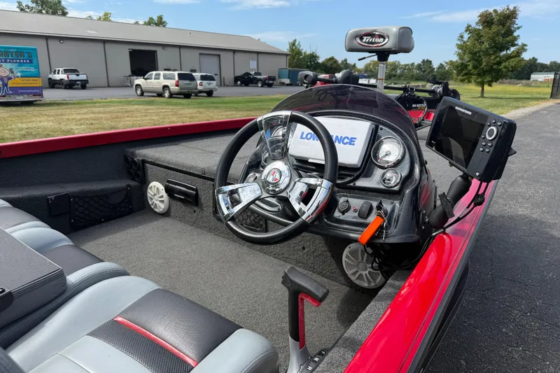Slide: The Image of 2018 Triton 18 TX boat interior with steering wheel and navigation equipment. - 9
