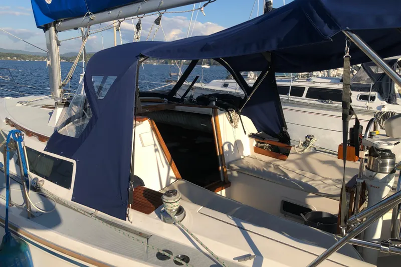 Slide: The Image of 1989 Catalina 30 MkII sailboat with blue canopy, docked on a sunny day. - 6