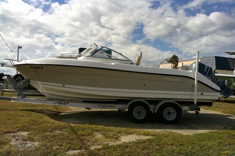 Slide: The Image of 2015 Pursuit DC 235 Dual Console boat on trailer under cloudy sky. - 0