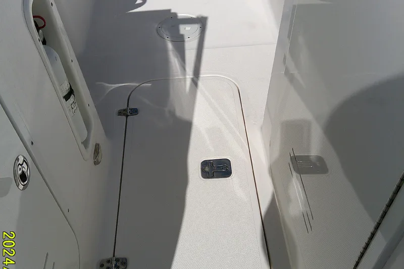 Slide: The Image of 2015 Pursuit DC 235 Dual Console boat deck with storage hatch and fire extinguisher. - 14