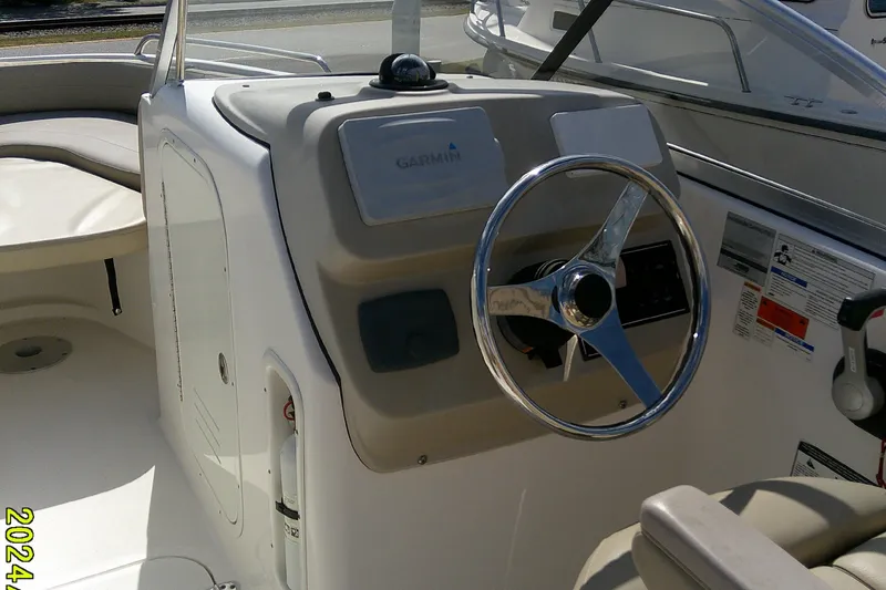 Slide: The Image of 2015 Pursuit DC 235 Dual Console boat interior with steering wheel and Garmin navigation system. - 19