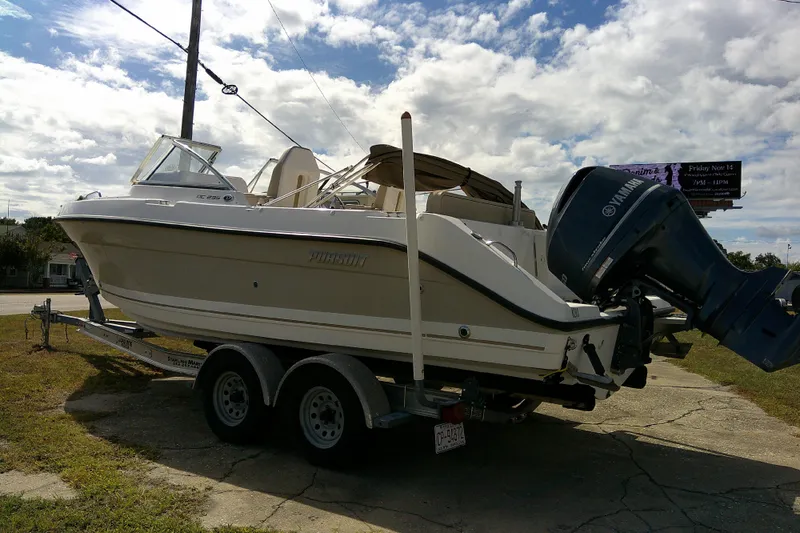 Slide: The Image of 2015 Pursuit DC 235 Dual Console boat on trailer, Yamaha outboard, cloudy sky background. - 2