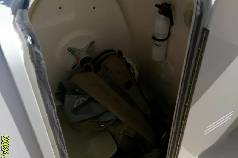 Slide: The Image of 2015 Pursuit DC 235 Dual Console storage area with fire extinguisher and gear. - 20