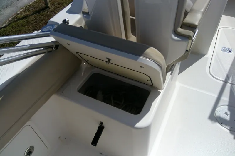 Slide: The Image of 2015 Pursuit DC 235 Dual Console boat seat storage compartment open. - 24