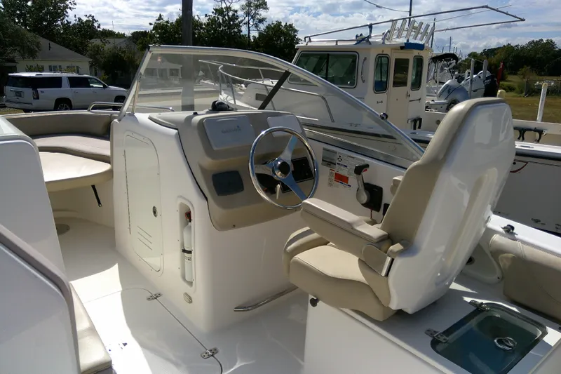 Slide: The Image of 2015 Pursuit DC 235 Dual Console boat interior with steering wheel and seating. - 26