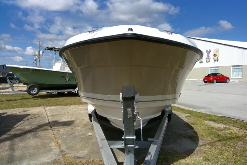 Slide: The Image of 2015 Pursuit DC 235 Dual Console boat on trailer, parked outdoors under blue sky. - 3