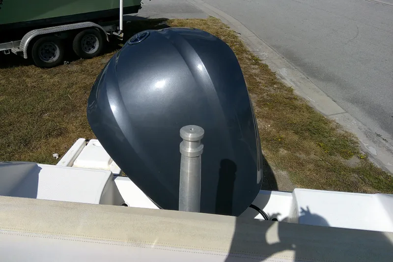 Slide: The Image of 2015 Pursuit DC 235 Dual Console boat engine, parked on grass near a road. - 31