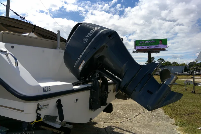 Slide: The Image of 2015 Pursuit DC 235 Dual Console boat with Yamaha outboard motor, parked outdoors. - 4