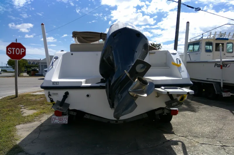 Slide: The Image of 2015 Pursuit DC 235 Dual Console boat with outboard motor, parked near a stop sign. - 5