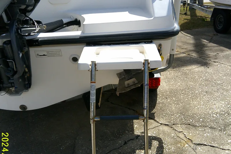 Slide: The Image of 2015 Pursuit DC 235 Dual Console boat with a foldable swim ladder. - 6