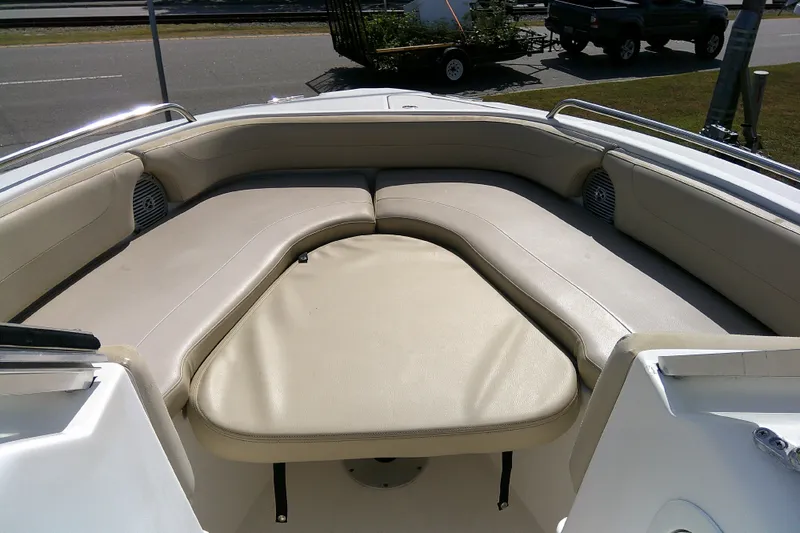 Slide: The Image of 2015 Pursuit DC 235 Dual Console boat with spacious beige seating area. - 7