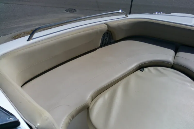 Slide: The Image of 2015 Pursuit DC 235 Dual Console boat interior with beige seating and speaker. - 8