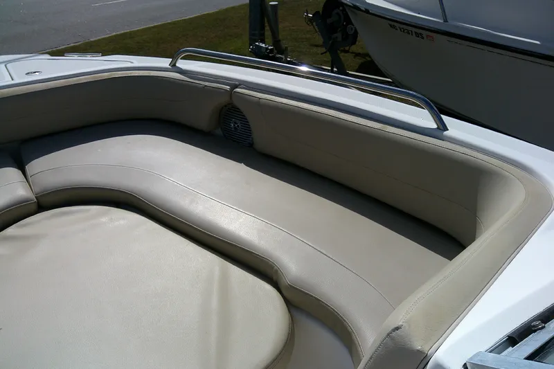 Slide: The Image of 2015 Pursuit DC 235 Dual Console boat interior with beige cushioned seating. - 9