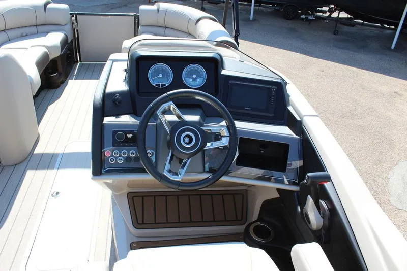 Slide: The Image of 2026 Avalon Catalina Quad Lounger Shift 25 FT boat dashboard with steering wheel and controls. - 18