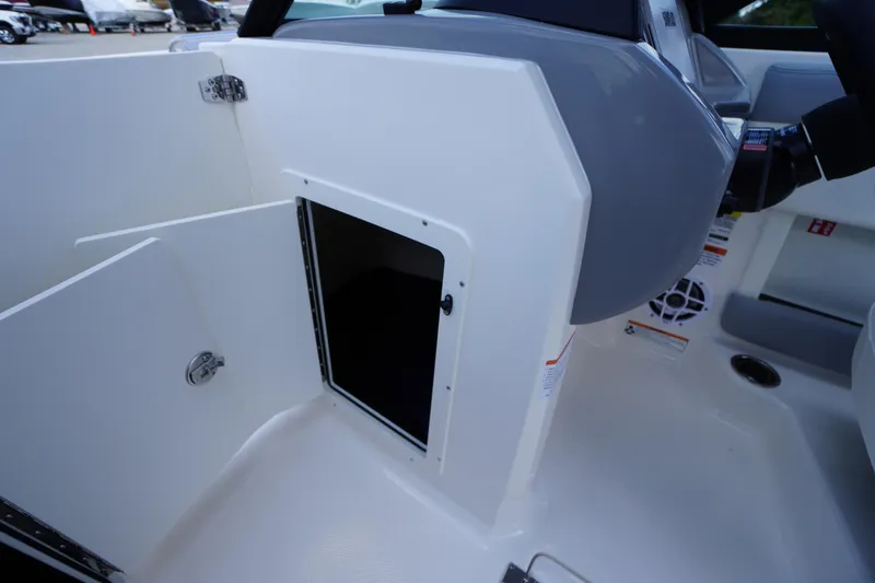 Slide: The Image of 2026 Chaparral 21 SSi OB boat interior storage compartment with open door. - 22