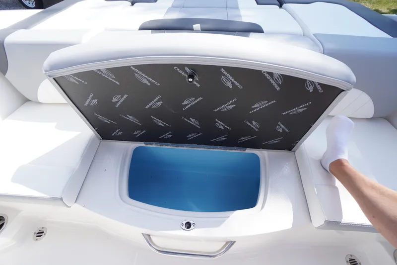 Slide: The Image of 2026 Chaparral 21 SSi OB boat storage compartment with open lid, showcasing interior space. - 32