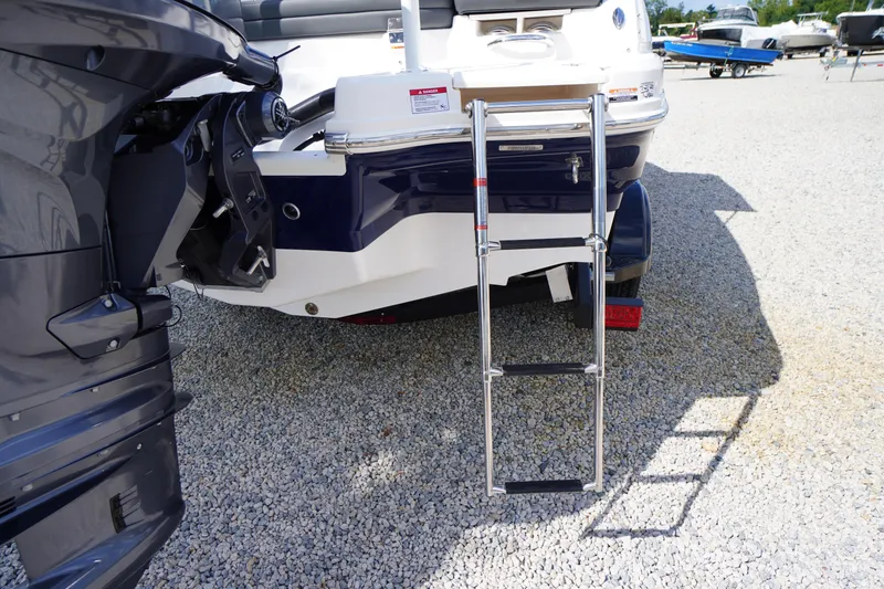 Slide: The Image of 2026 Chaparral 21 SSi OB boat with extended swim ladder on gravel surface. - 39