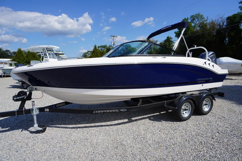 Slide: The Image of 2026 Chaparral 21 SSi OB boat on trailer, blue and white design, parked outdoors. - 45