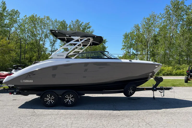 The Image of 2023 Yamaha Boats 252SD on trailer, sleek design, parked outdoors. - 0