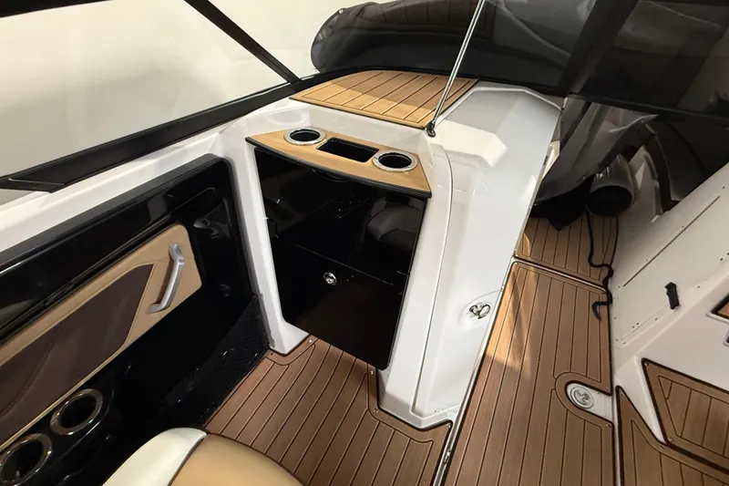 Slide: The Image of 2023 Yamaha Boats 252SD interior with sleek design, wood accents, and cup holders. - 24