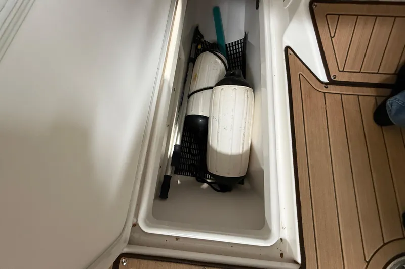 Slide: The Image of Storage compartment on 2023 Yamaha Boats 252SD, containing boat fenders and accessories. - 34