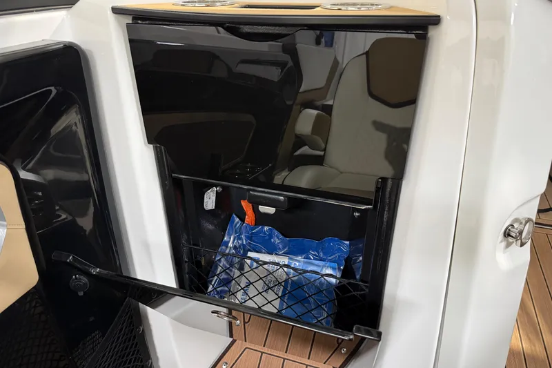Slide: The Image of 2023 Yamaha Boats 252SD interior storage compartment with netting and seating. - 38