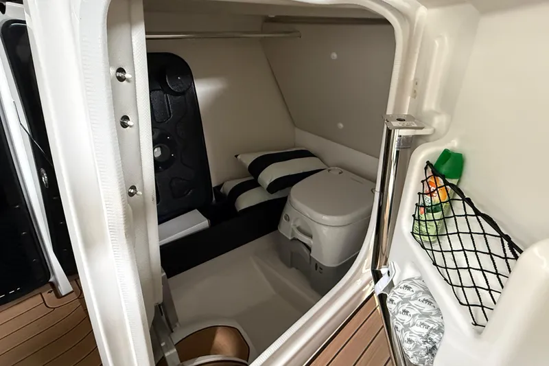 Slide: The Image of 2023 Yamaha Boats 252SD interior cabin with toilet and storage space. - 9