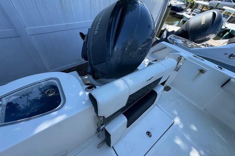 Slide: The Image of 2021 Tidewater 210 CC Adventure boat with Yamaha outboard motor, docked near other boats. - 15